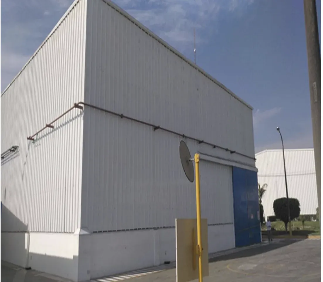 Fachada de nave cerrada con panel metálico y portón industrial en el testero